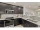 Modern kitchen features stainless steel appliances, gray backsplash, and undermount sink with grey countertops at 619 Brennan Cir, Erie, CO 80516