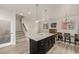 Open concept kitchen with a dark island and dining area including a light fixture hanging overhead at 619 Brennan Cir, Erie, CO 80516