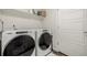 Well-lit laundry room equipped with Whirlpool washer and dryer and ample shelving space at 619 Brennan Cir, Erie, CO 80516