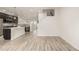 Bright living area with wood floors leading into the kitchen, a dining table and stairwell at 619 Brennan Cir, Erie, CO 80516