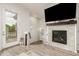 Bright living room with a modern fireplace, wood floors, and access to outdoor patio at 619 Brennan Cir, Erie, CO 80516
