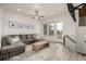Living room featuring a gray sofa, wooden flooring, and views of outdoor balcony at 619 Brennan Cir, Erie, CO 80516