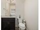 Compact powder room features a modern vanity, mirror, and toilet, creating a functional space at 619 Brennan Cir, Erie, CO 80516