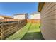 Well-maintained backyard featuring artificial turf, wood fence and neighboring houses at 1820 Taos St, Brighton, CO 80603