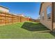 Well-maintained backyard with artificial turf, wood fence, and mature landscaping at 1820 Taos St, Brighton, CO 80603