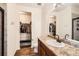 Well-maintained bathroom featuring a single sink vanity, wood floors, and a walk-in closet for storage at 1820 Taos St, Brighton, CO 80603