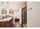 Inviting bathroom featuring wood floors, a single sink vanity, and a glass-enclosed shower, providing a spa-like experience at 1820 Taos St, Brighton, CO 80603