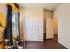 Bedroom featuring wood floors, closet with sliding doors, and a sunflower-themed wall at 1820 Taos St, Brighton, CO 80603