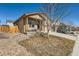 Side view of the home with a covered porch and well-manicured lawn at 1820 Taos St, Brighton, CO 80603