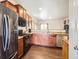 Modern kitchen with dark wood cabinets, black appliances, and spacious countertops at 1820 Taos St, Brighton, CO 80603