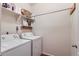 Functional laundry room with white washer and dryer, plus storage shelves at 1820 Taos St, Brighton, CO 80603