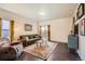 Bright living room with wood floors, area rug, comfortable seating, and sliding glass doors to the backyard at 1820 Taos St, Brighton, CO 80603