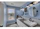 Elegant bathroom with double sinks, granite countertop, modern fixtures, and a bright window overlooking the landscape at 5537 Lake Gulch Rd, Castle Rock, CO 80104