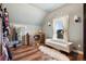 Charming bedroom featuring a vanity, an oversized mirror, and a plush white bench beneath a bright window at 5537 Lake Gulch Rd, Castle Rock, CO 80104