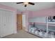 A cozy, pink bedroom with a bunk bed, a charming wooden door, and a spacious closet for ample storage at 5537 Lake Gulch Rd, Castle Rock, CO 80104