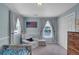 Cozy bedroom featuring comfortable armchair, twin windows, and a classic wooden dresser, creating a serene retreat at 5537 Lake Gulch Rd, Castle Rock, CO 80104