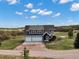 Aerial view of home with a blue exterior, three-car garage, and beautiful green landscaping at 5537 Lake Gulch Rd, Castle Rock, CO 80104