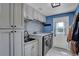 Laundry room with front load washer and dryer and granite folding counter at 5537 Lake Gulch Rd, Castle Rock, CO 80104