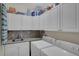 Functional laundry room with washer, dryer, sink, and storage cabinets for added convenience at 5537 Lake Gulch Rd, Castle Rock, CO 80104