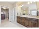 Beautiful primary bath with dual sinks, wood cabinets, and tile floors at 6503 S Quemoy Way, Aurora, CO 80016