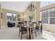 Spacious dining room with modern chandelier and furniture adjacent to a living space with ample natural light at 6503 S Quemoy Way, Aurora, CO 80016