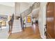 Elegant foyer with a curved staircase, hardwood floors, and a view of the living room with a fireplace at 6503 S Quemoy Way, Aurora, CO 80016