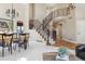 Elegant foyer with view of a curved staircase, dining room, and comfortable sitting area in the background at 6503 S Quemoy Way, Aurora, CO 80016