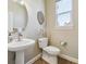 Stylish powder room features a pedestal sink, decorative mirror, and modern fixtures at 6503 S Quemoy Way, Aurora, CO 80016