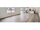 Spacious living area with wood-look floors, large windows, and an open layout leading to the kitchen at 15285 Milwaukee St, Thornton, CO 80602