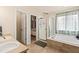 Bright bathroom featuring double sinks, a soaking tub, and a separate glass-enclosed shower at 1128 S Duquesne Cir, Aurora, CO 80018