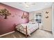 Cozy bedroom featuring a charming accent wall, whimsical decor, and a bright window at 1128 S Duquesne Cir, Aurora, CO 80018