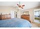 Bedroom with carpet, ceiling fan, and wooden dressers, with view of the bathroom from doorway at 1128 S Duquesne Cir, Aurora, CO 80018