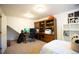 Neutral bedroom featuring a built-in wood desk and shelving, decorated with golf clubs at 1128 S Duquesne Cir, Aurora, CO 80018