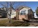 Charming home featuring a well-kept front yard, an attached two car garage, and brick accents at 1128 S Duquesne Cir, Aurora, CO 80018
