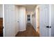 Hallway with wood-look tile leads to laundry room with washer and dryer, lots of natural light at 1128 S Duquesne Cir, Aurora, CO 80018