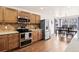 Updated kitchen featuring stainless steel appliances, wooden cabinets and an adjacent dining area at 1128 S Duquesne Cir, Aurora, CO 80018