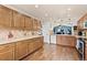 Spacious kitchen featuring ample wood cabinetry, tiled backsplash, stainless steel appliances, and wood floors at 1128 S Duquesne Cir, Aurora, CO 80018