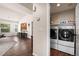 Convenient laundry area with washer, dryer, and shelving, seamlessly connected to the kitchen and main living areas at 1128 S Duquesne Cir, Aurora, CO 80018