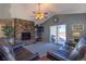 Cozy living room with stone fireplace, ceiling fan, and sliding glass doors at 1128 S Duquesne Cir, Aurora, CO 80018