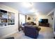 Relaxing living room with neutral carpet, leather chairs, TV, and bookshelves at 1128 S Duquesne Cir, Aurora, CO 80018