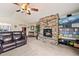 Spacious living room featuring a stone fireplace, high ceilings, and a large sofa at 1128 S Duquesne Cir, Aurora, CO 80018