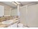 Neutral toned bathroom featuring a single sink, tiled counter, and a shower with sliding glass doors at 6382 Freeport Dr, Highlands Ranch, CO 80130