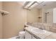 Neutral toned bathroom featuring a single sink, tiled counter, and a shower reflected in the mirror at 6382 Freeport Dr, Highlands Ranch, CO 80130