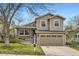 Inviting tan two-story home showcasing a two-car garage and well-manicured lawn at 6382 Freeport Dr, Highlands Ranch, CO 80130