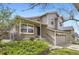 Charming tan home featuring a brick facade and a two-car garage at 6382 Freeport Dr, Highlands Ranch, CO 80130