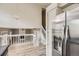 Bright kitchen featuring stainless steel refrigerator and view of living space with fireplace and light wood floors at 6382 Freeport Dr, Highlands Ranch, CO 80130