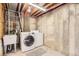 Unfinished basement laundry area with washer, dryer, utility sink, and exposed beams at 6382 Freeport Dr, Highlands Ranch, CO 80130