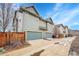 Townhome exterior with three single car garages and driveways on a sunny day at 5193 N Clinton St, Denver, CO 80238