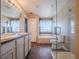 Elegant bathroom featuring double sinks, a soaking tub, and a glass shower at 13616 Garfield St # B, Thornton, CO 80602