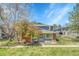 Inviting townhome with a brick facade, a well-manicured lawn, and mature trees enhancing the curb appeal and charm at 1287 S Wheeling Way, Aurora, CO 80012